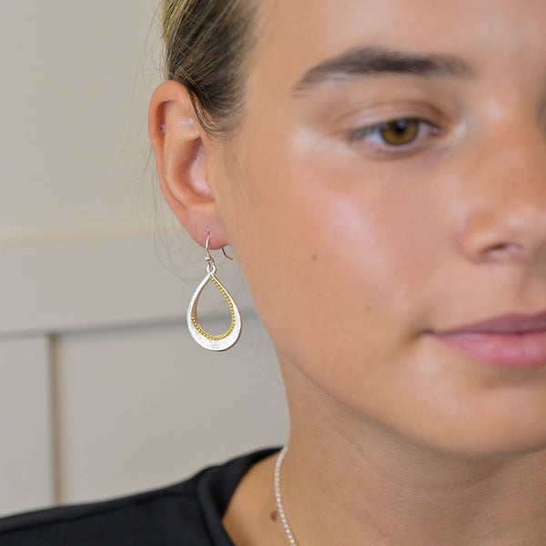 Silver plated brushed twist teardrop earrings with golden bead detail