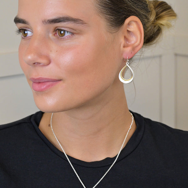 Silver plated brushed twist teardrop earrings with golden bead detail