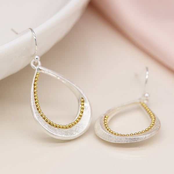 Silver plated brushed twist teardrop earrings with golden bead detail