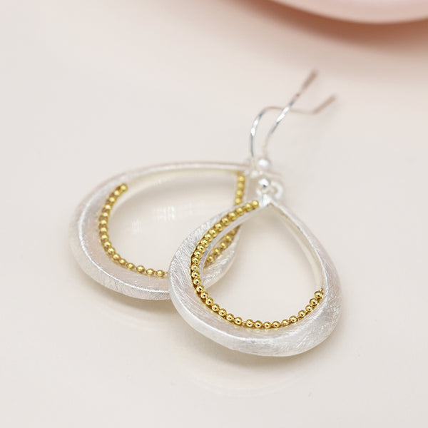 Silver plated brushed twist teardrop earrings with golden bead detail