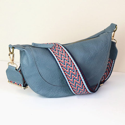 DENIM BLUE VEGAN HALF MOON BAG WITH RED/BLUE WOVEN ZIG ZAG STRAP